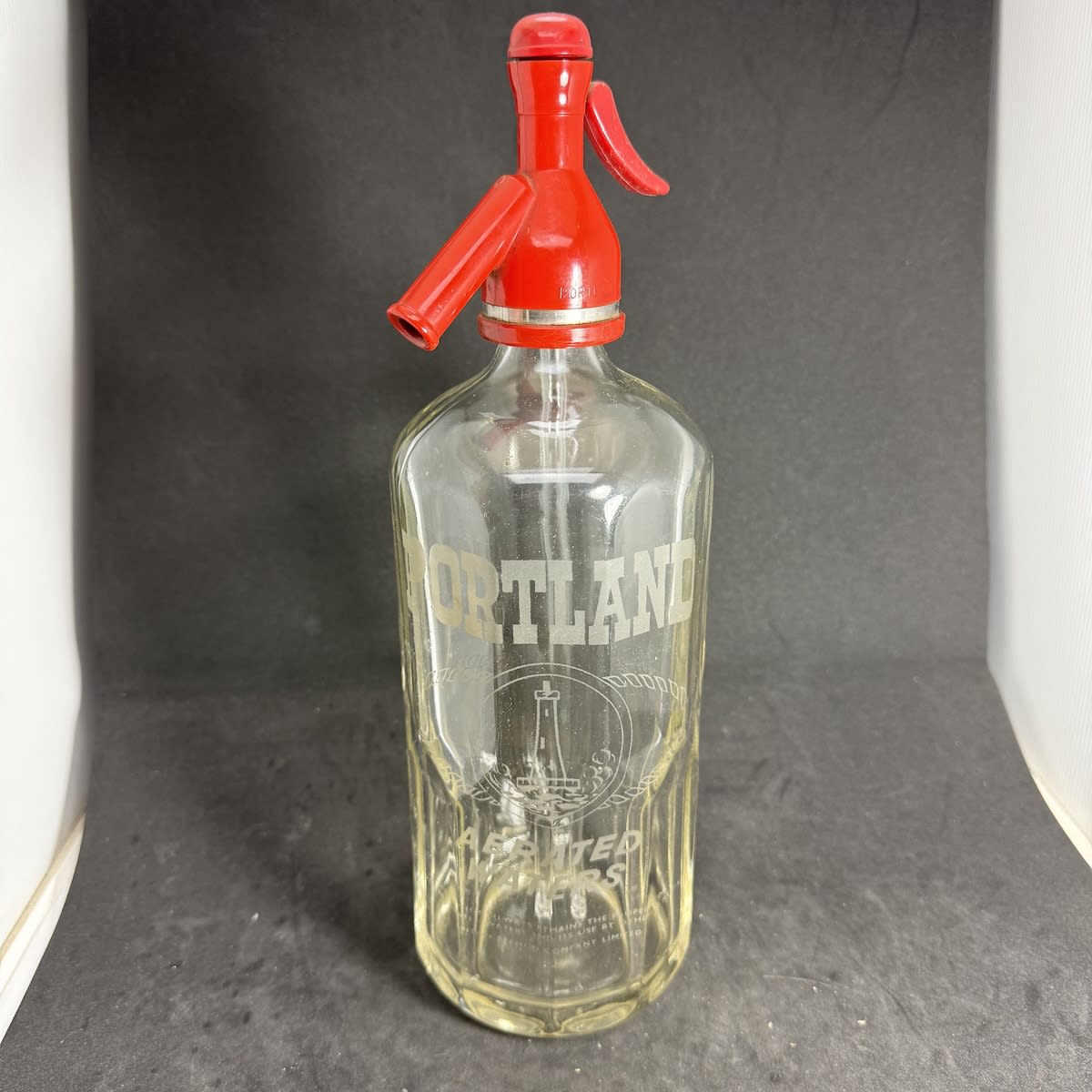 Soda Syphon. Portland Aerated Waters. Lighthouse. St James shape. Clear. 30 oz. Original plastic top. (Victoria)