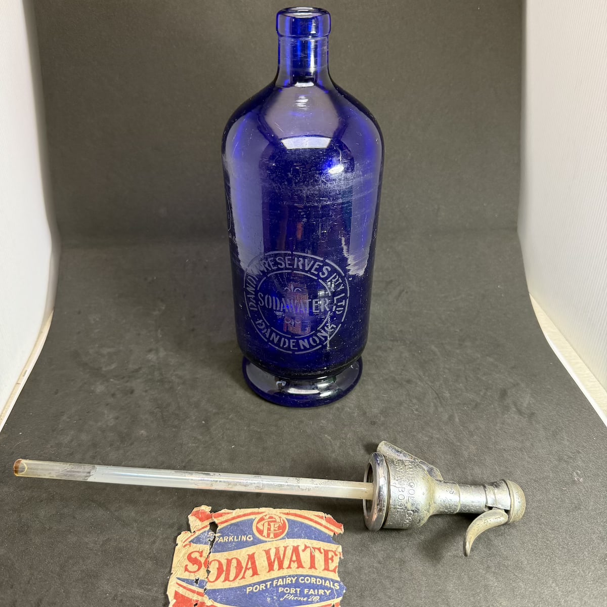 Soda Syphon. Hand engraved: J. Osborne, J. O. and also an O roughly engraved on the base (Dubbo). Also etched via a stencil: Dandy Preserves Pty Ltd / Soda Water / Dandenong. Originally also had a Port Fairy Cordials label over the Dandy part. Spout engraved Warrnambool Cordials! (New South Wales & Victoria)