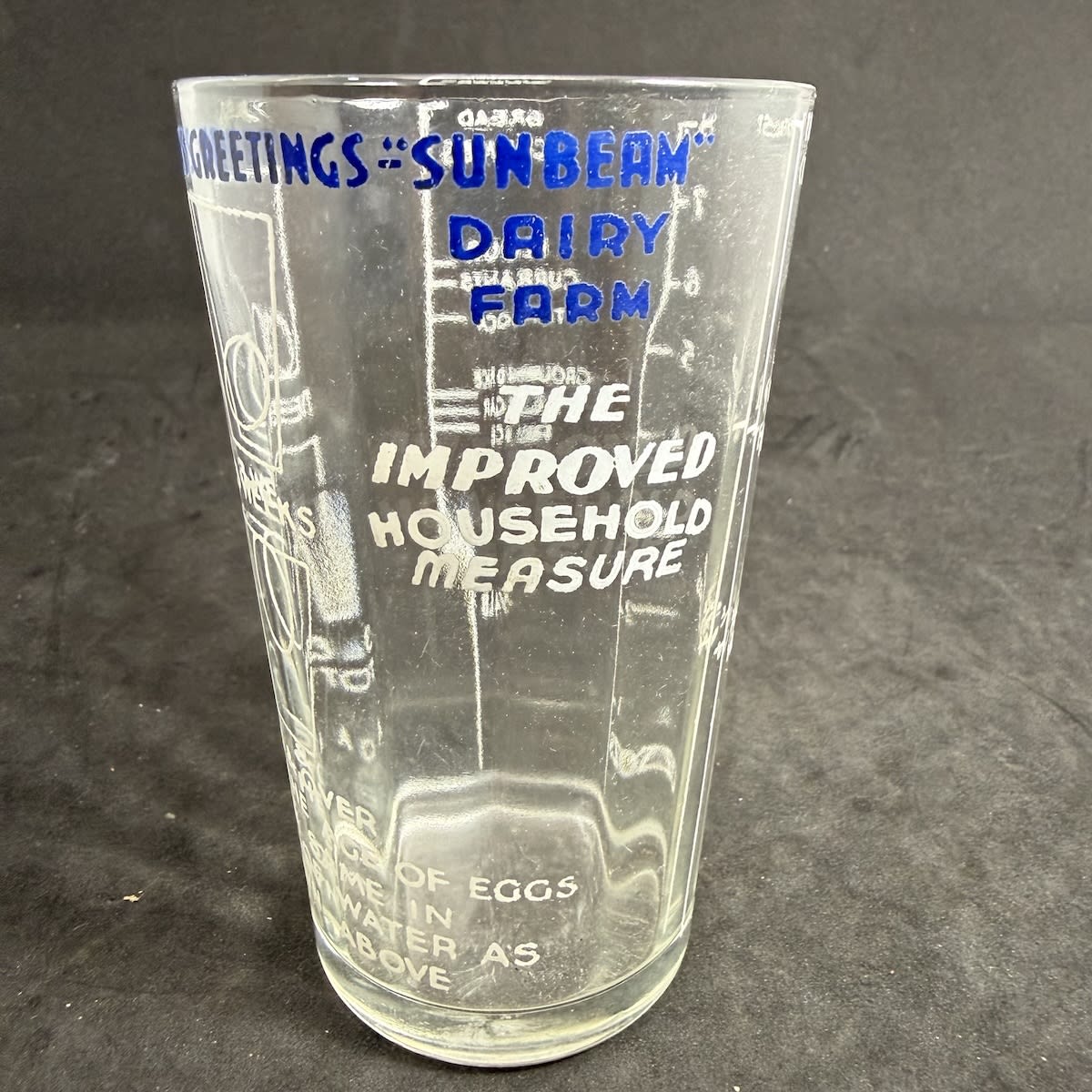 Advertising Measuring Glass: Seasons Greetings "Sunbeam" Dairy Farm. The Improved Household Measure. Egg test. Measurements and different products listed for 1/4 lb measure.