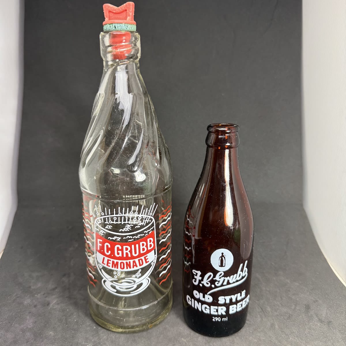 2 Ceramic Label Bottles. Both F. C. Grubb, Gladstone. Internal Thread Lemonade 24 oz. 290 ml amber glass Ginger Beer. (South Australia)