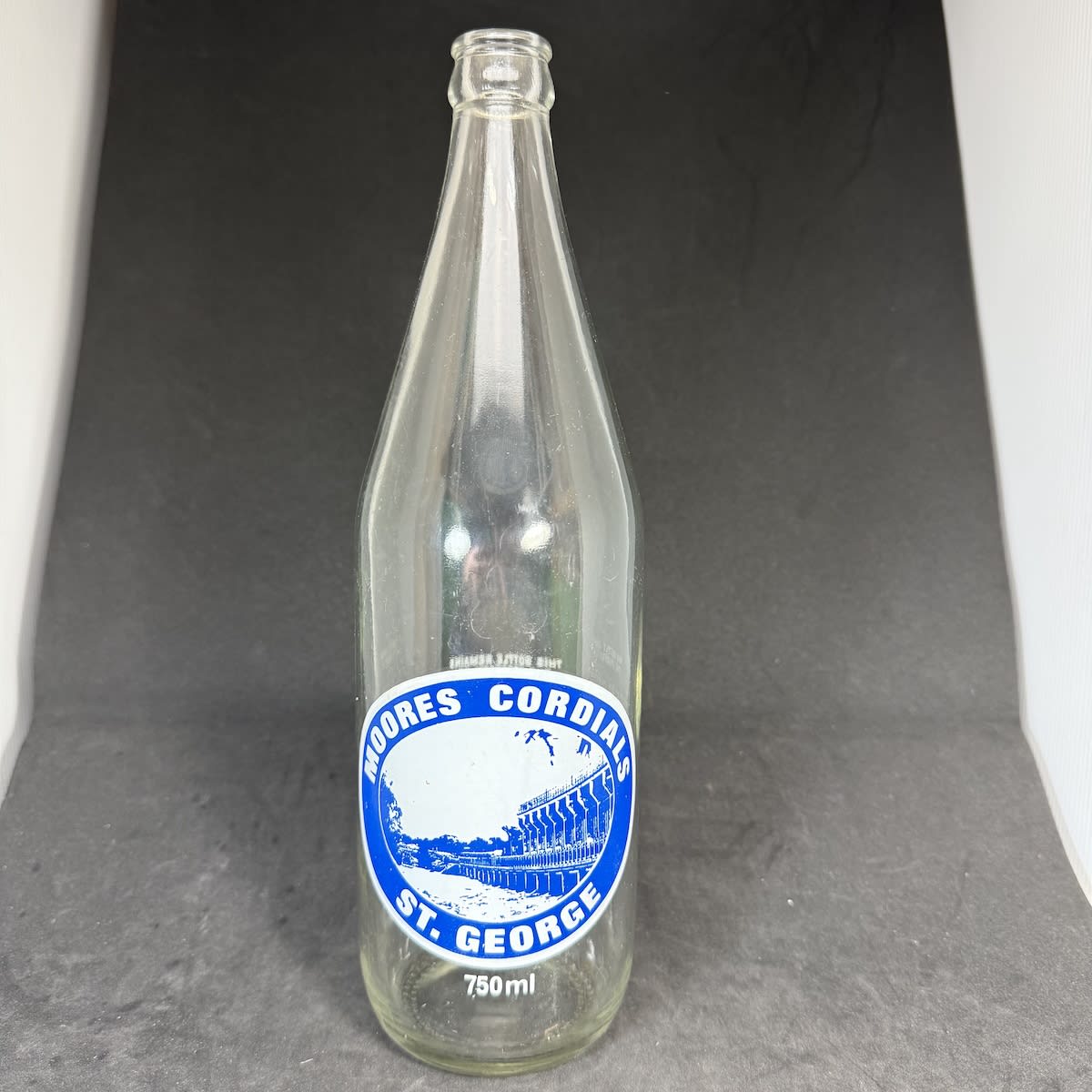 Ceramic Label Crown Seal. Moores Cordials, St. George. Blue and white print. 750 ml. (Queensland)