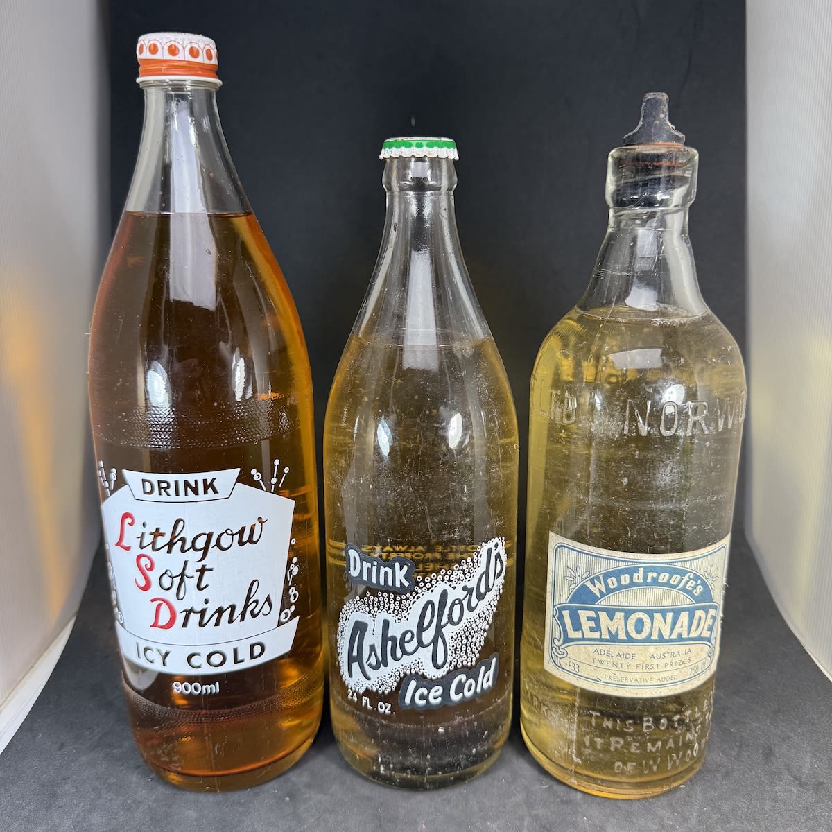 3 Sealed and Full Aerated Waters: Lithgow Soft Drinks Dry Ginger 900 ml; Ashelfords bottle with Orbells Dubbo cap for Lime Flavour; Woodroofes Lemonade Internal Thread.