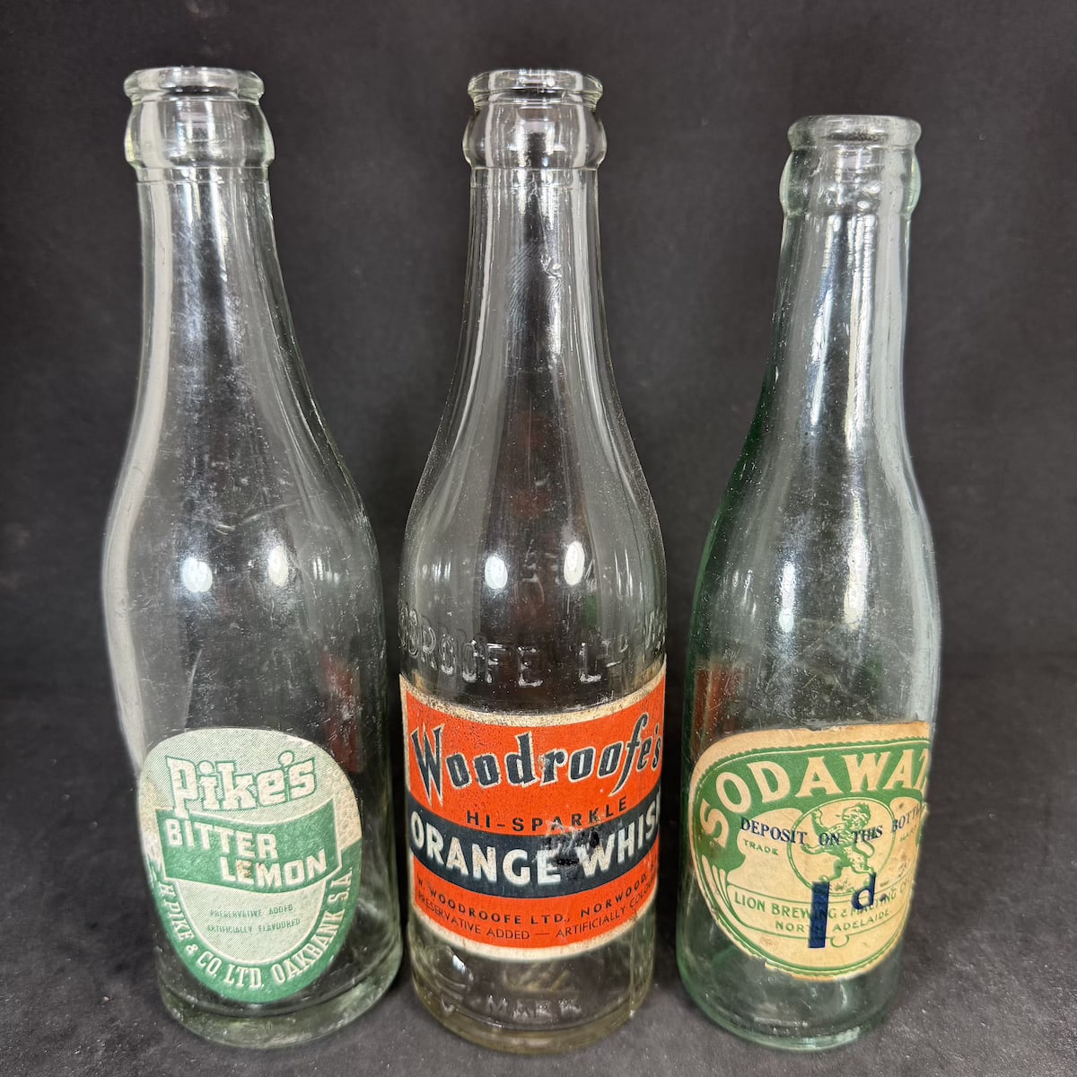 3 SA Crown Seals with original labels: Pikes Oakbank, Bitter Lemon; Woodroofe's Norwood, Orange Whisk; Lion Brewing & malting Co North Adelaide, Soda Water. (South Australia)