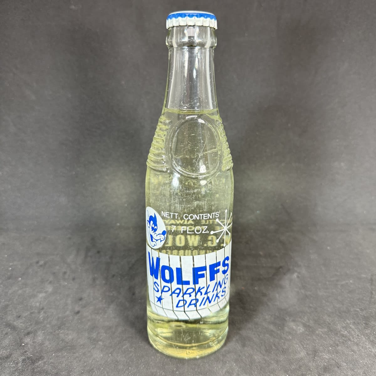 Ceramic Label Crown Seal. Wolffs Sparkling Drinks. W. C. Wolff, Mundubbera. Bullet type 7 oz. Still sealed with contents. (Queensland)