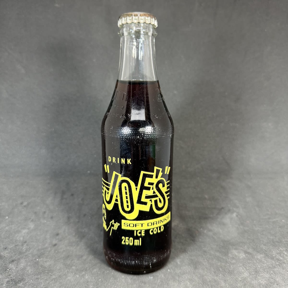 Ceramic Label Crown Seal. Joe's, Korumburra. "One Trippa". Clear. 250 ml. Still sealed with Cola cap. (Victoria)