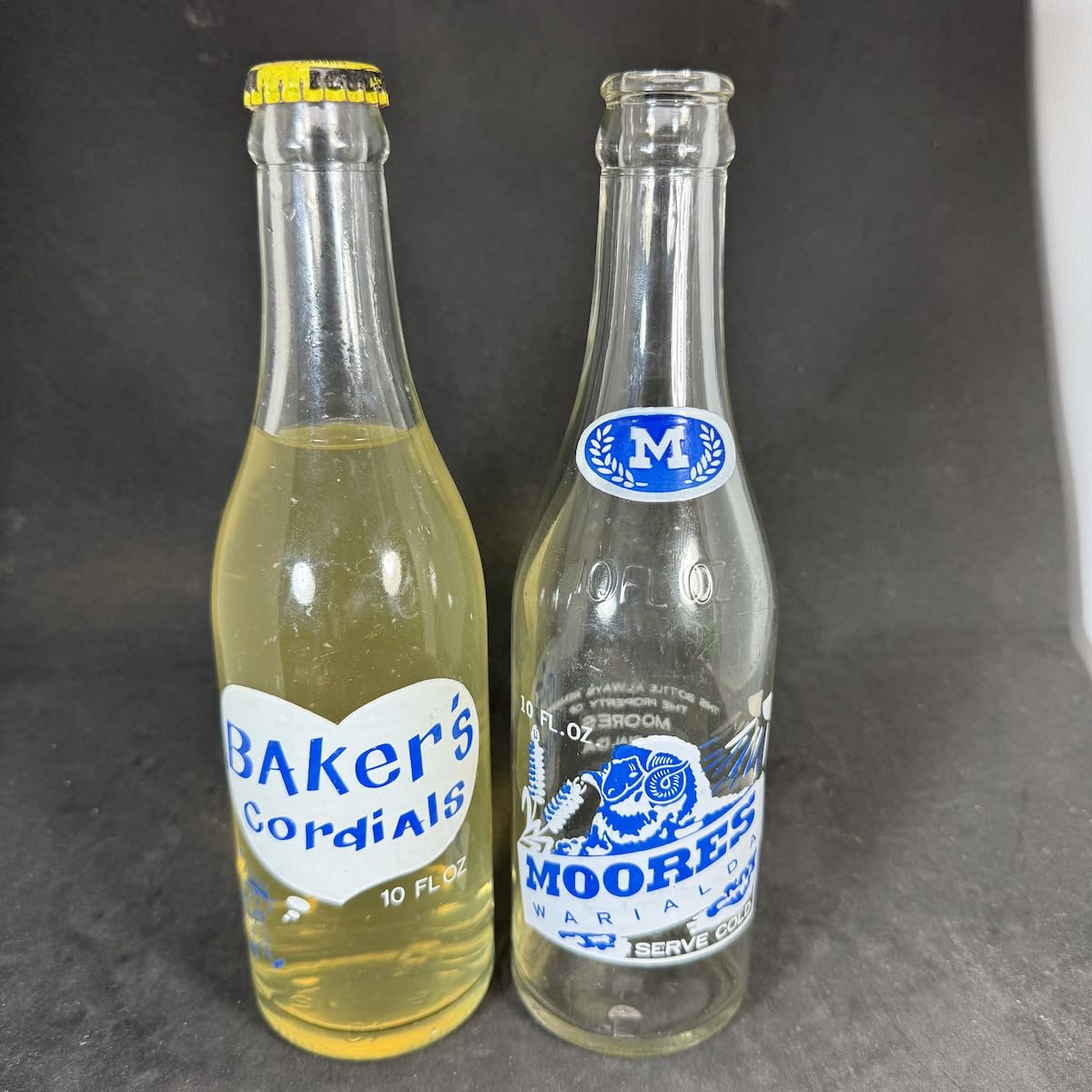 2 Ceramic Label Crown Seals. Baker's Cordials, A. S. Baker & Sons, Boggabri, still sealed with contents and Pineapple cap; Moores Warialda. 10 oz. Blue & White Prints. (New South Wales)