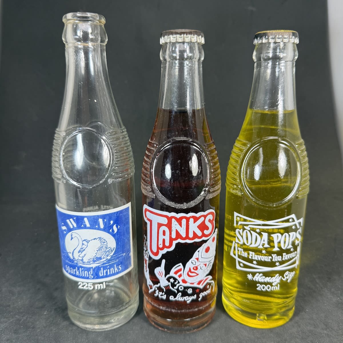 3 Ceramic Label Crown Seals. Bullet types. Swan's Sparkling Drinks, L. P. Swan & Son, Beverley; Tanks, West Wyalong. Sealed with Cola Cap; Soda Pops, Chapel St., St. Kilda. Sealed with Pineapple cap. (Western Australia, New South Wales & Victoria)
