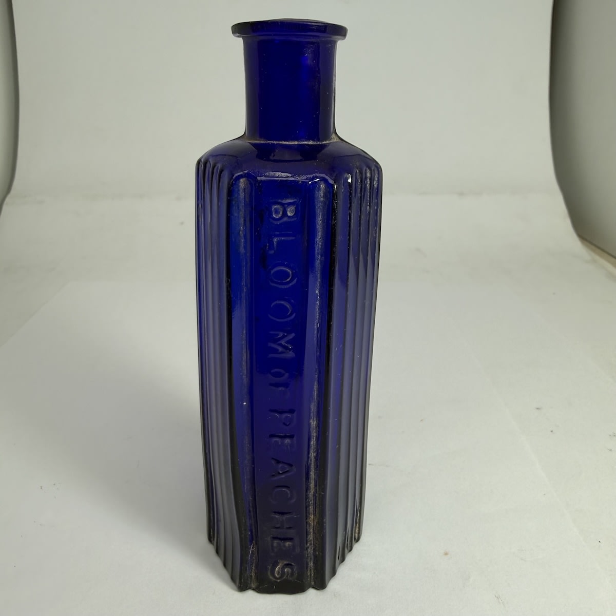 Poison/Cosmetic. Bloom of Peaches. No base mark. Hexagonal. Cobalt Blue. (William Ball, Chemist, Melbourne, Victoria)