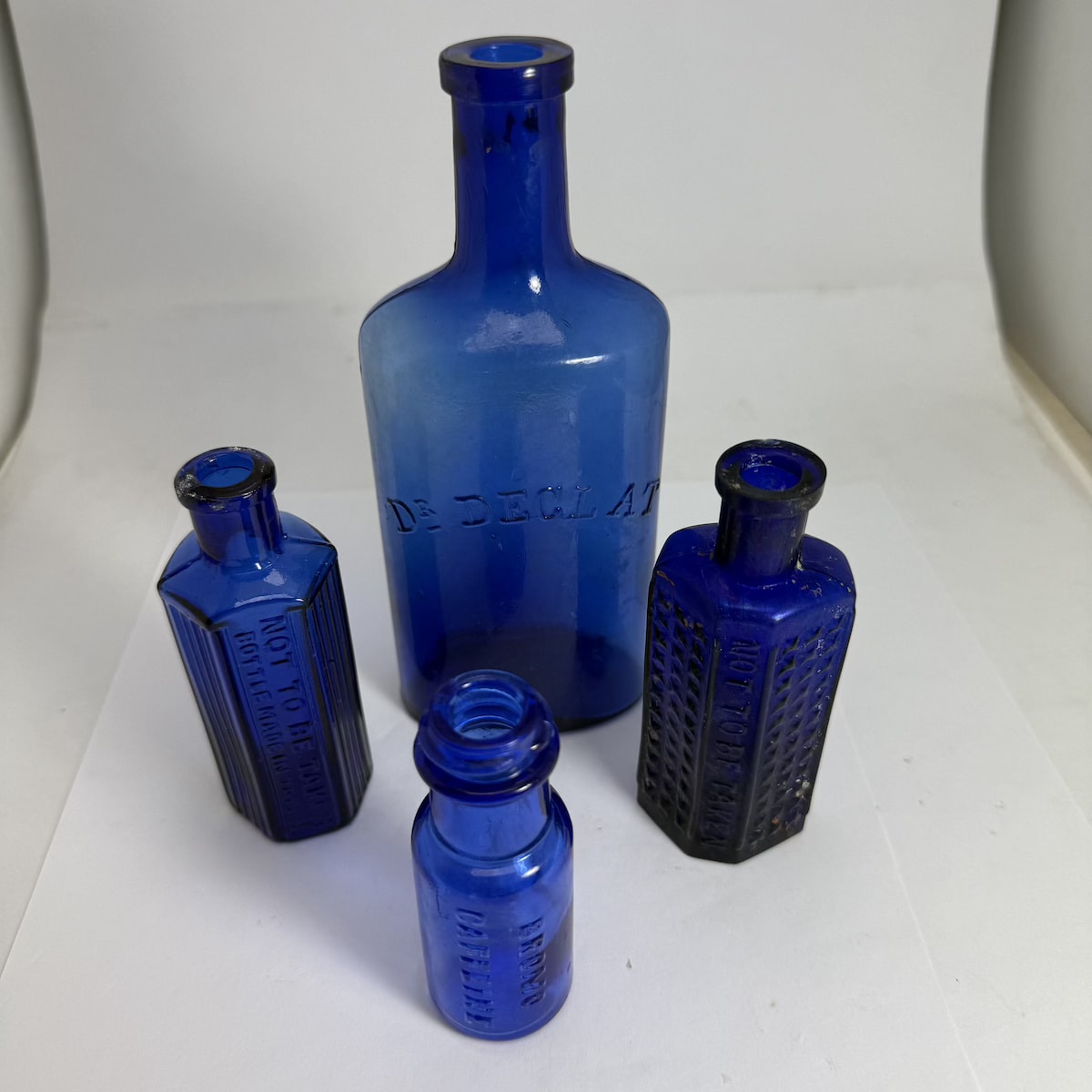 4 Blue Bottles: Dr Declat; 2 NTBT, Not to be taken poisons, one bottle made in japan; Bromo Caffeine.
