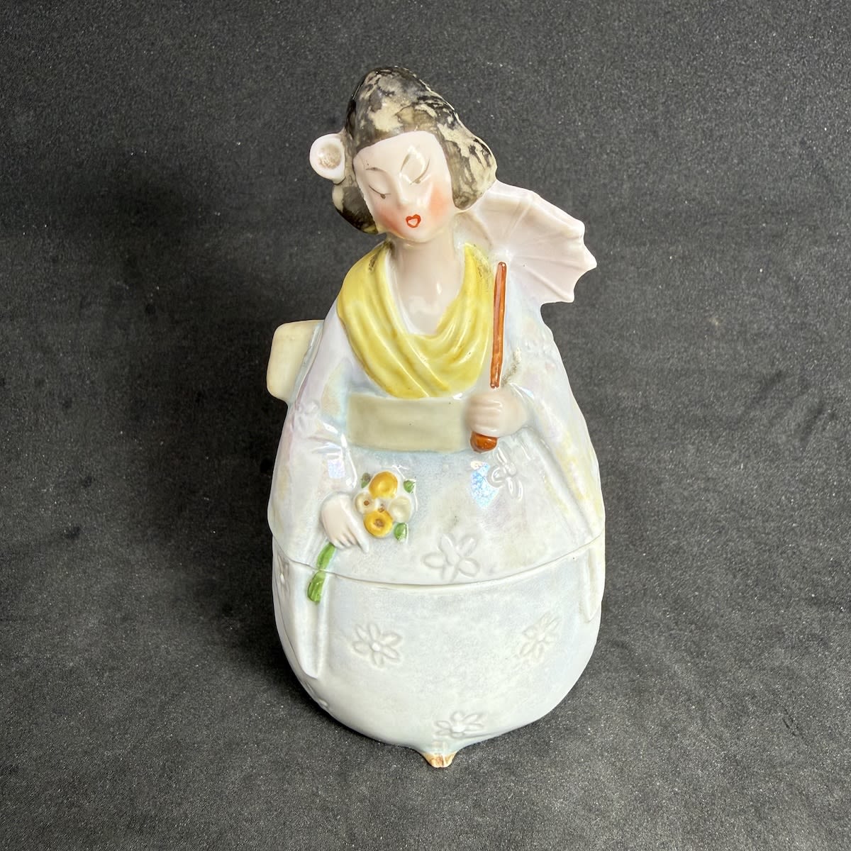 Inkwell. Three part porcelain inkwell. Figural of Japanese style lady with parasol and flower. Pen holder behind the parasol on the figures back. Inkwell inside.