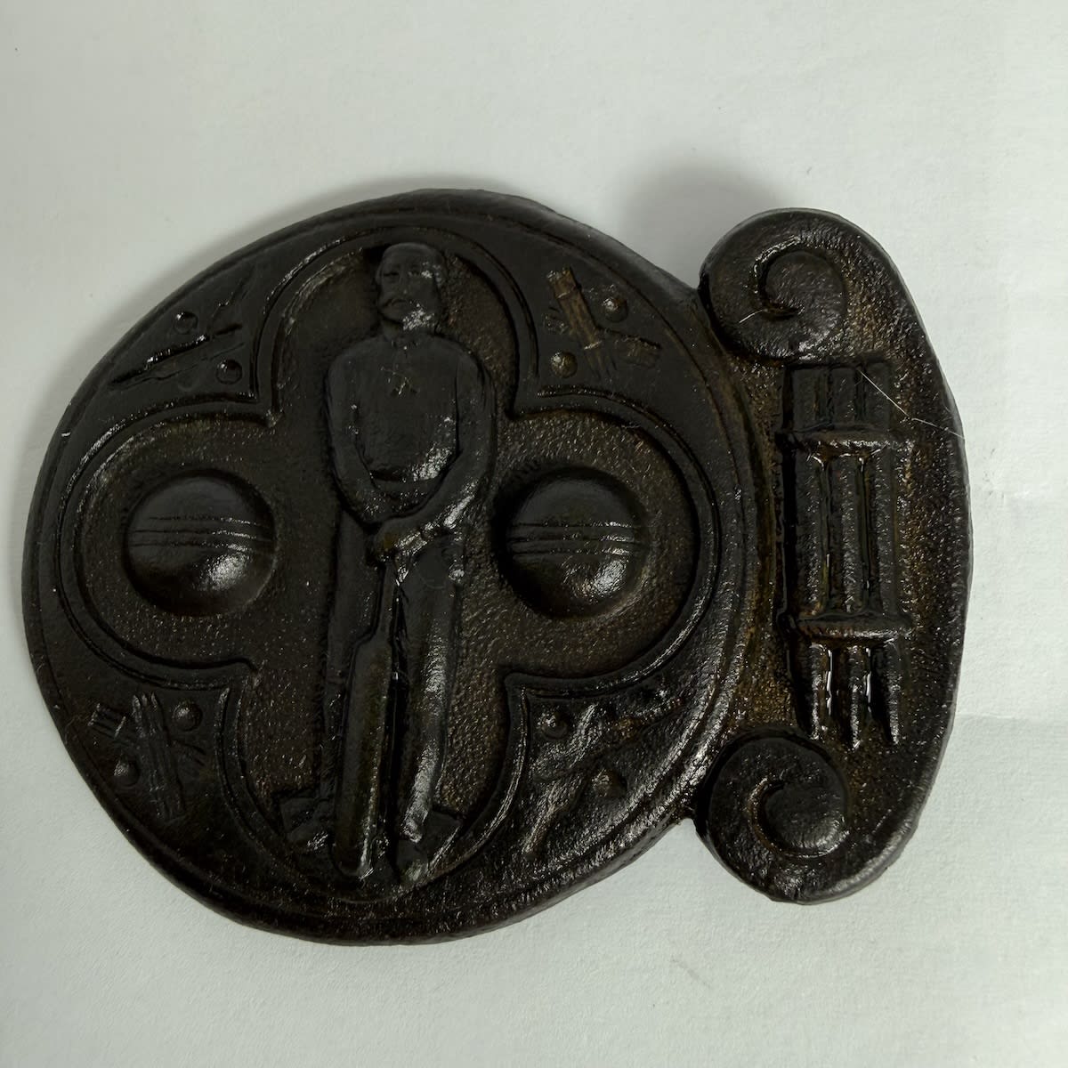 Cricket Belt Buckle. Batsman holding bat in front of him. Two cricket balls. Crossed bats, stumps and balls around the edge. Stumps on one side.