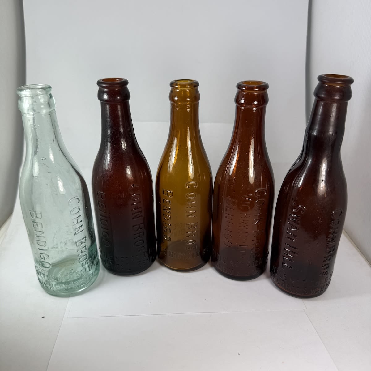 5 different Cohn Bros Bendigo, Swan Hill Crown Seals. Amber & Aqua. Swan Hill one with a really crude stretched out neck. (Victoria)