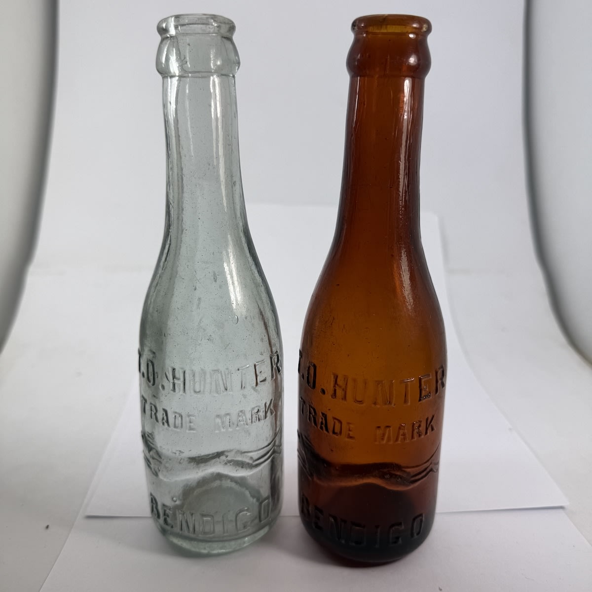 2 small T. O. Hunter Bendigo Crown Seals with Crossways embossing. Long necks. Greyish Aqua & Mid Amber. 6 oz. (Victoria)
