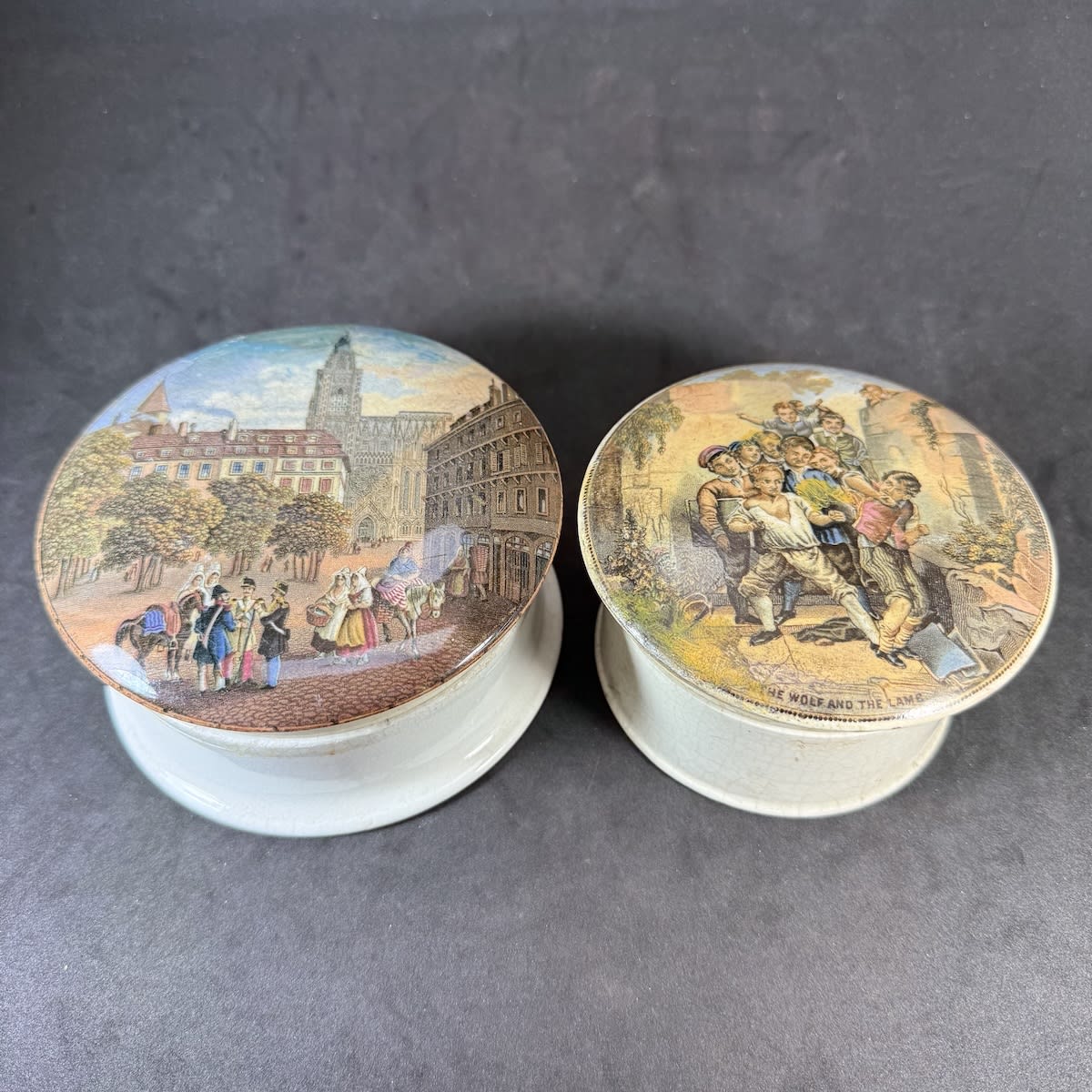 2 Prattware Pot Lids. Strasbourg, street scene; The Wolf and the Lamb. With fitting bases.