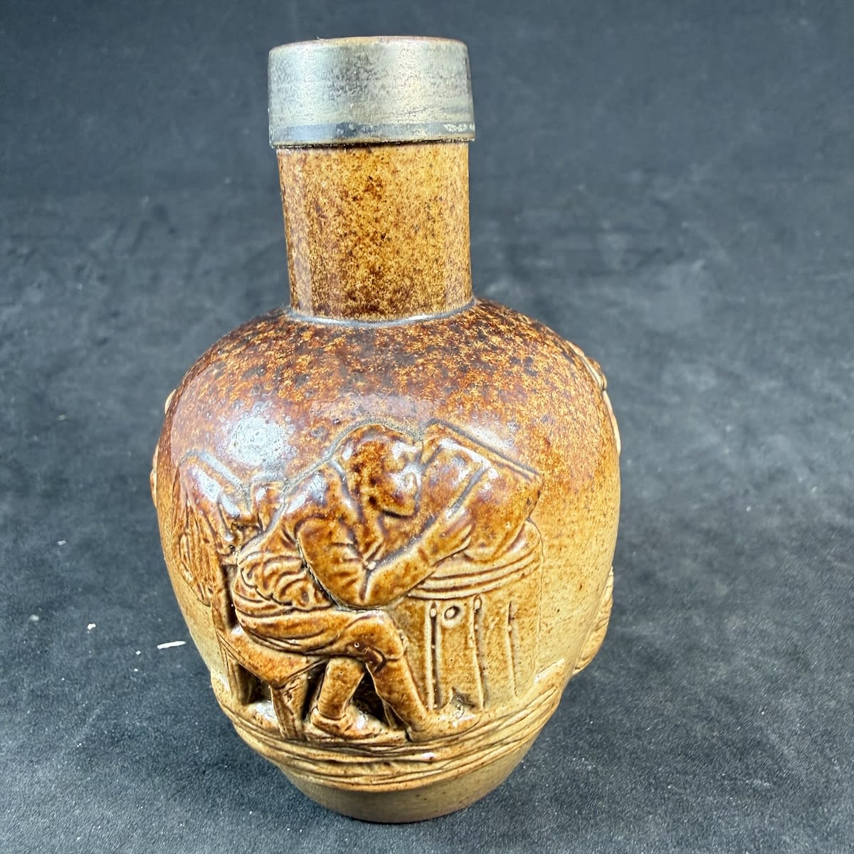 Mini Stoneware Jug. Salt Glaze. Applied decoration of Man studying a book; Windmill; Tree. Small markings on the base but hard to read.