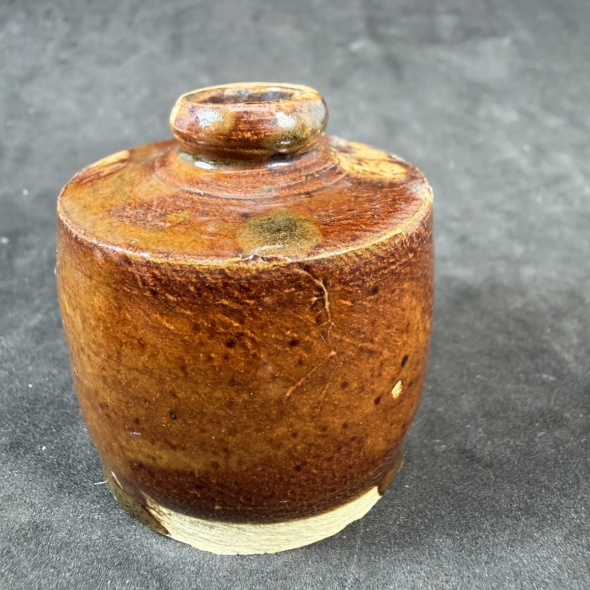 Penny Ink! Not your standard one though. Highly glazed with concentric circles, potters string line across base. Tan glaze with pale glaze spots.