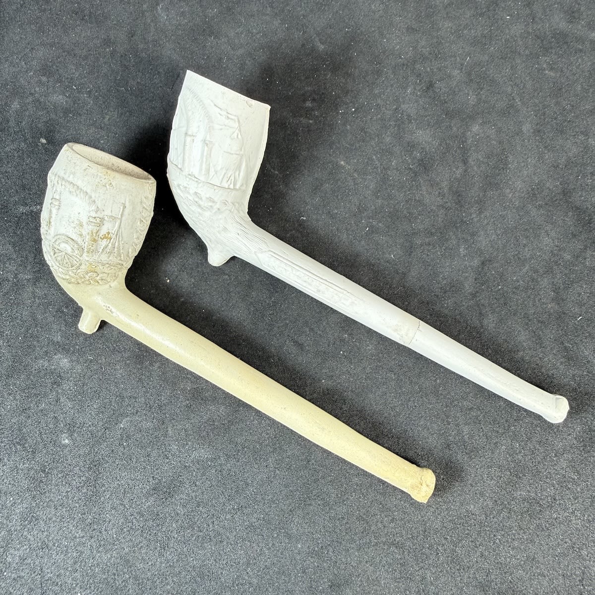 2 Clay Pipes: Ship Canal Manchester with Steam Ship & Sailing Ship; Steam Ship & Steam Train. Moulded clay pipes.