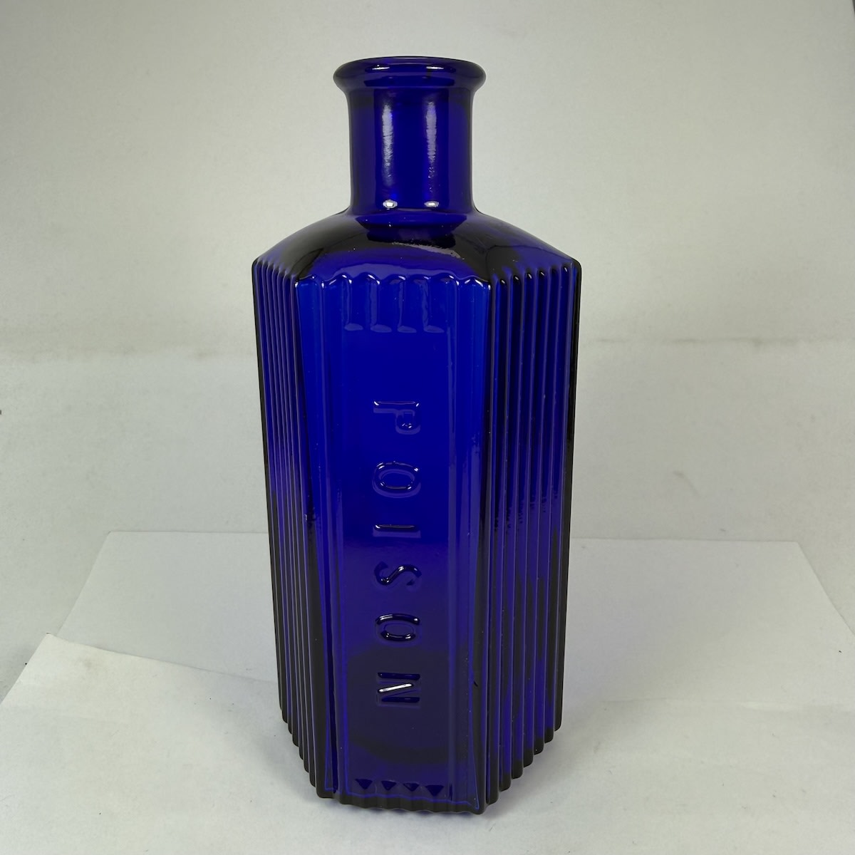 Poison. Hexagonal Cobalt Blue Poison. Vertical grooves around and either side of embossed panel. 8 to base.