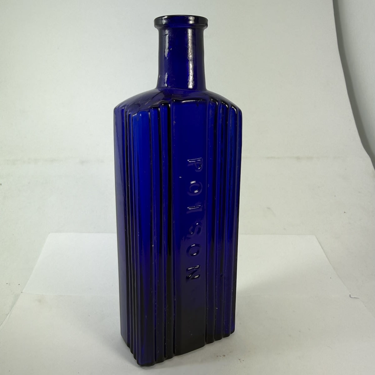 Poison. Oblong with deep grooves either side of the embossed panel and to the front half of each of the side panels. No base mark. 6 oz. 161 mm.