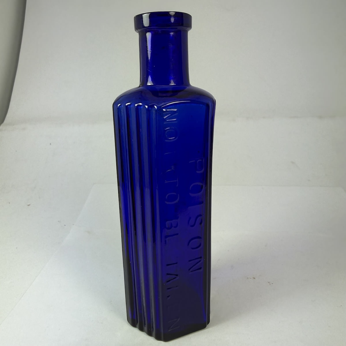 Poison. Poison, Not to be taken. Hexagonal. Deep grooves to panels either side of embossed panel. 3 oz embossed on base. 130 mm. Sans Serif style embossing.