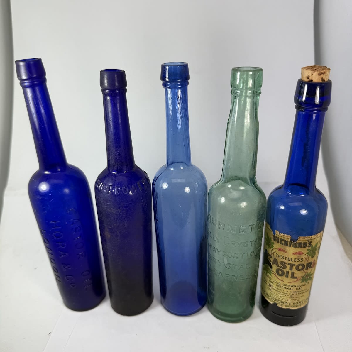 5 Castor Oils: Hora & Co London; Jno H Power & Co London; Plain early one; Burnets Jelly Crystals advertising; Labelled A. M. Bickford & Sons Adelaide & Brisbane.