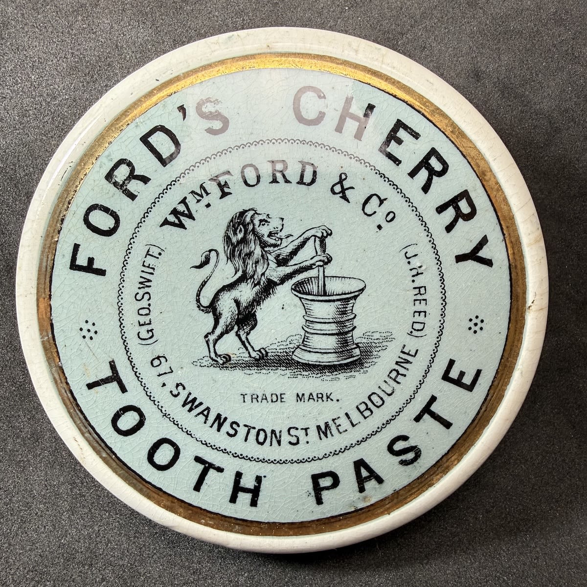 Pot Lid. Ford's Cherry Tooth Paste. Wm Ford & Co Swanston St Melbourne. Geo. Swift, J. H. Reed. Rampant Lion with Mortar & Pestle. Bright Blue background, gold border. (Victoria)