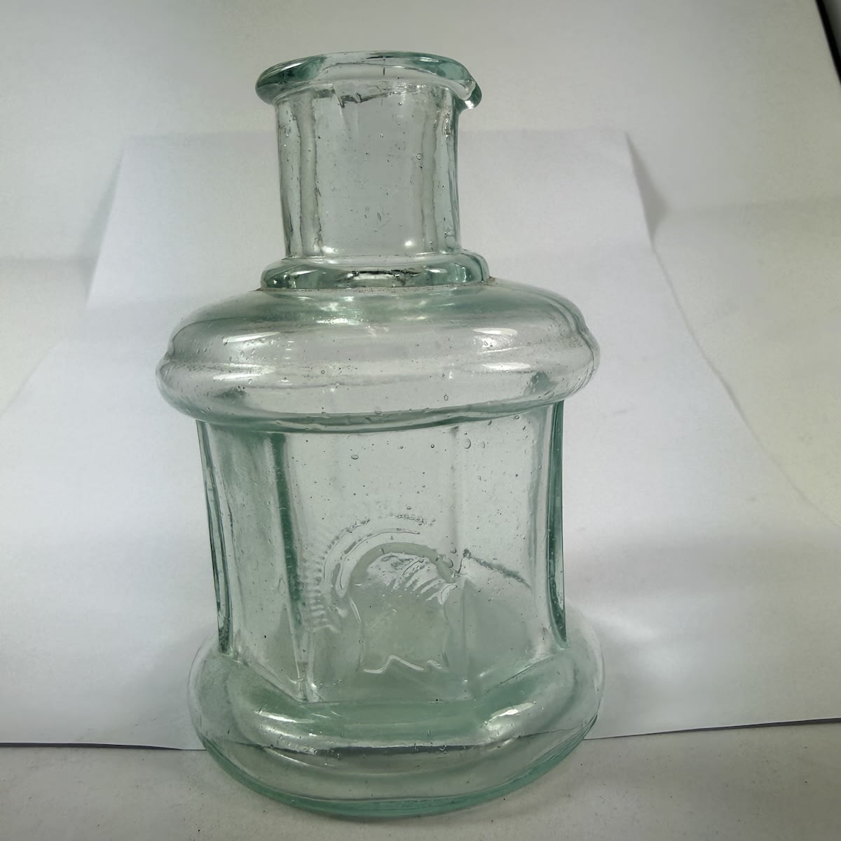 Ink. Centurian Head. Cotton reel type shape but with eight flat panels around the middle. Pouring lip. Aqua. 2 oz.