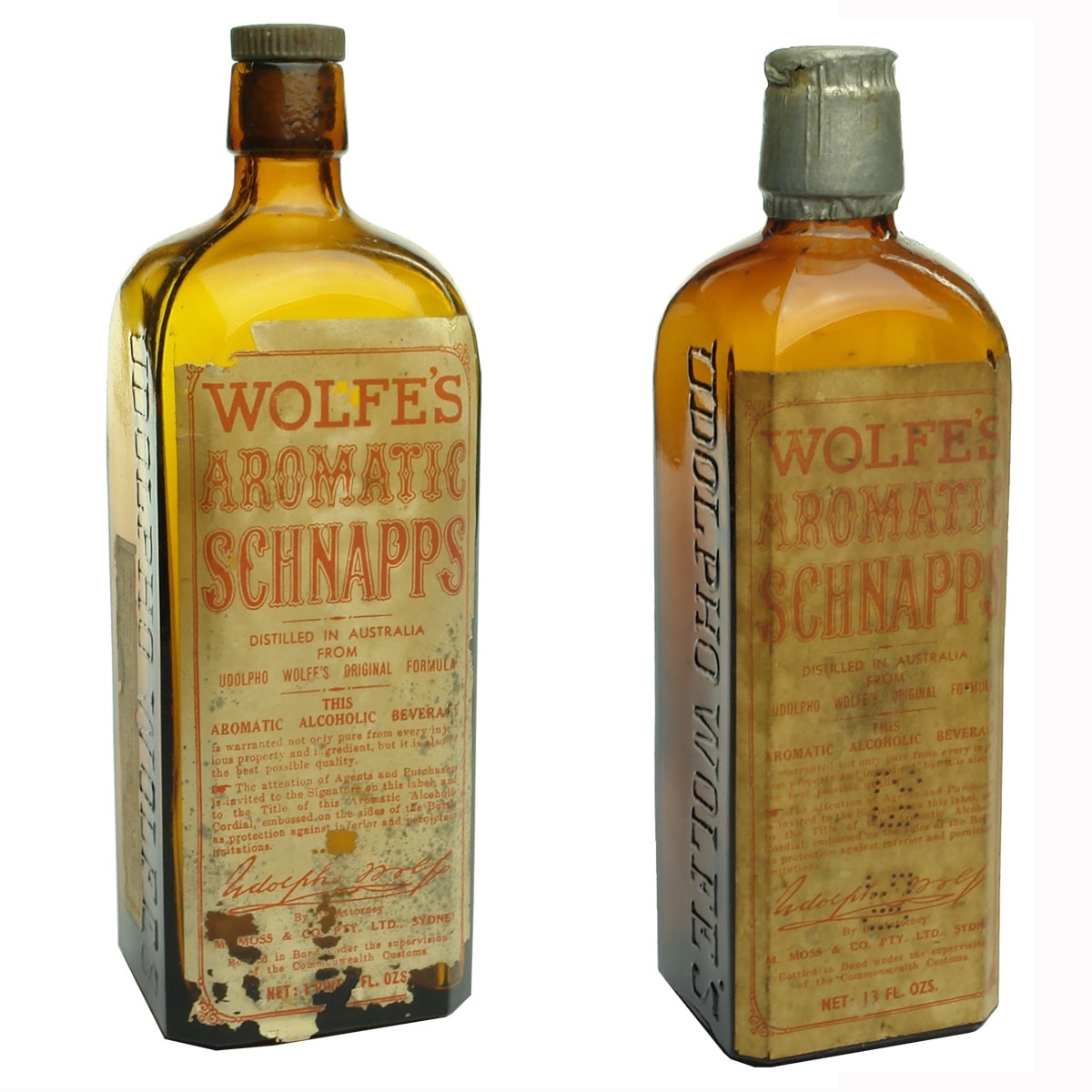 2 Labelled Udolpho Wolfe's Schnapps. M. Moss & Co Pty Ltd Sydney Agents. Side label on the large one mentions temporary use of amber bottles as green not available.