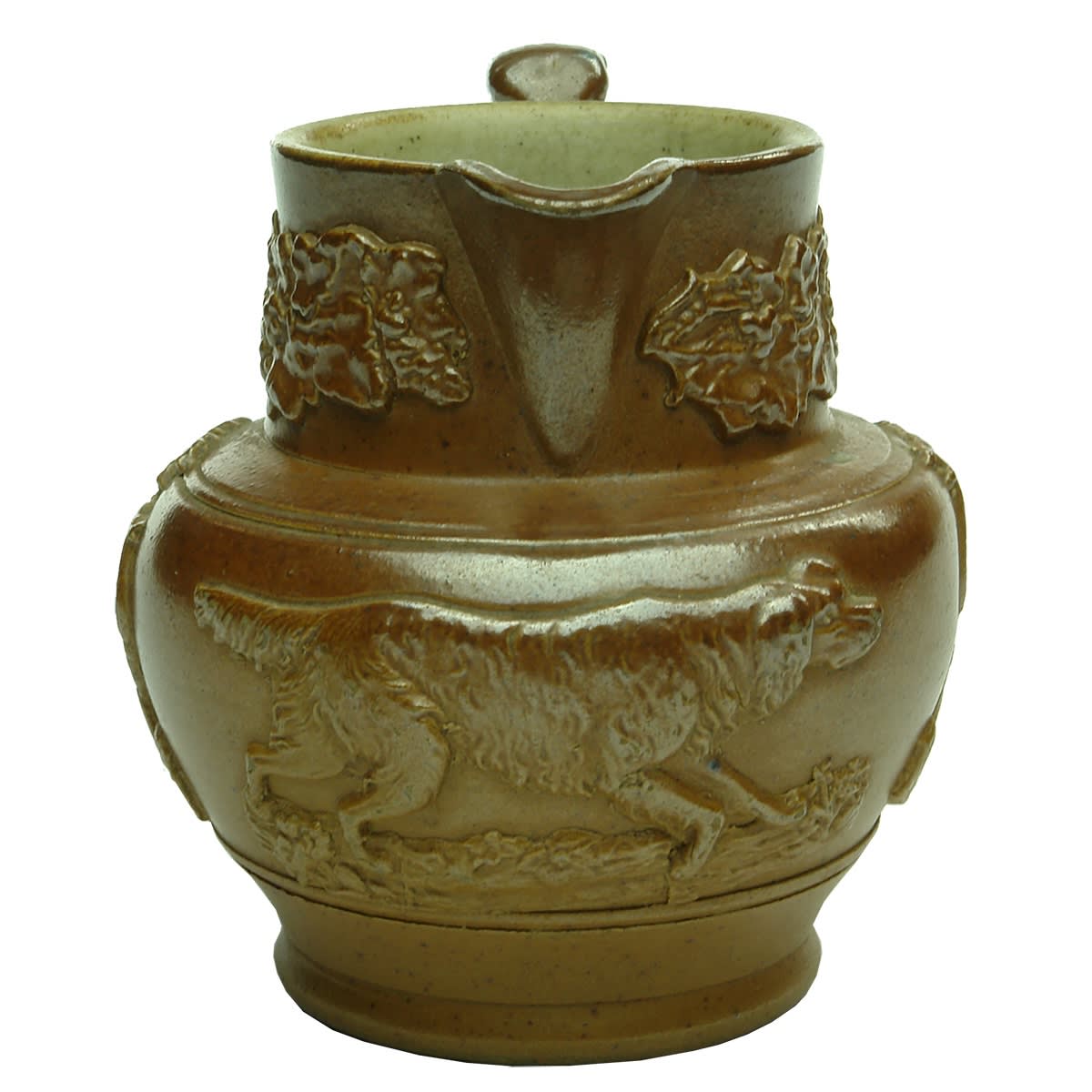 Harvestware Jug. Lady with Harp on either side. Large Dog to the middle. Sausage Dog Handle. Grapes and Leaves around neck. No potters stamp.