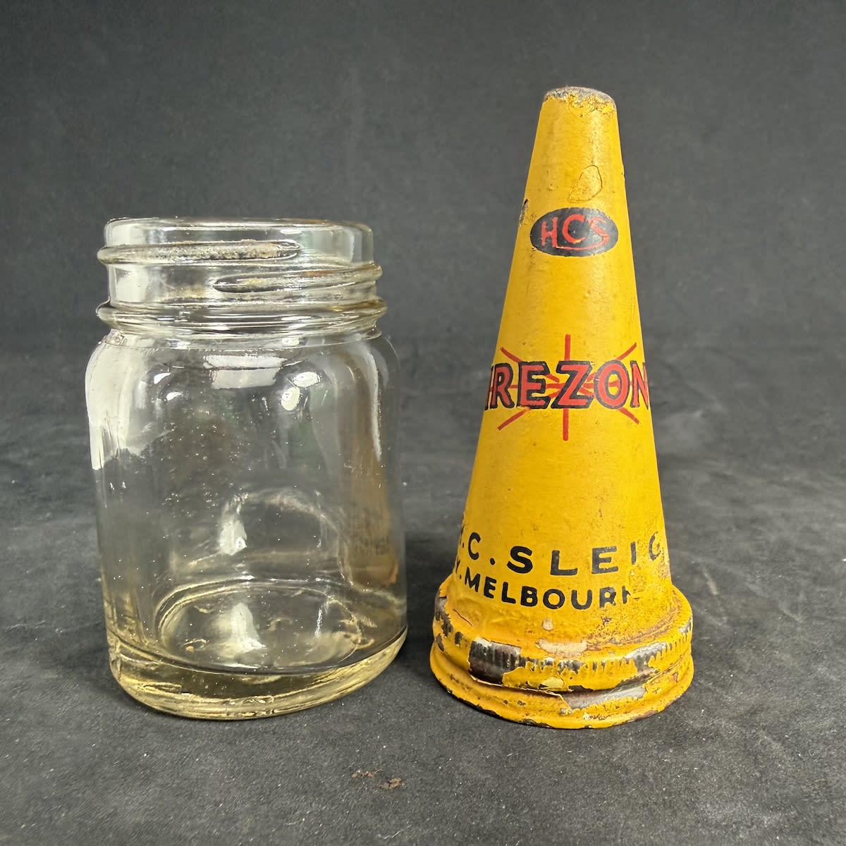 Tin pourer on tiny glass jar. Firezone. HCS. H. C. Sleigh. Sydney, Melbourne, Adelaide. Jar with base AGM, 2, A225.