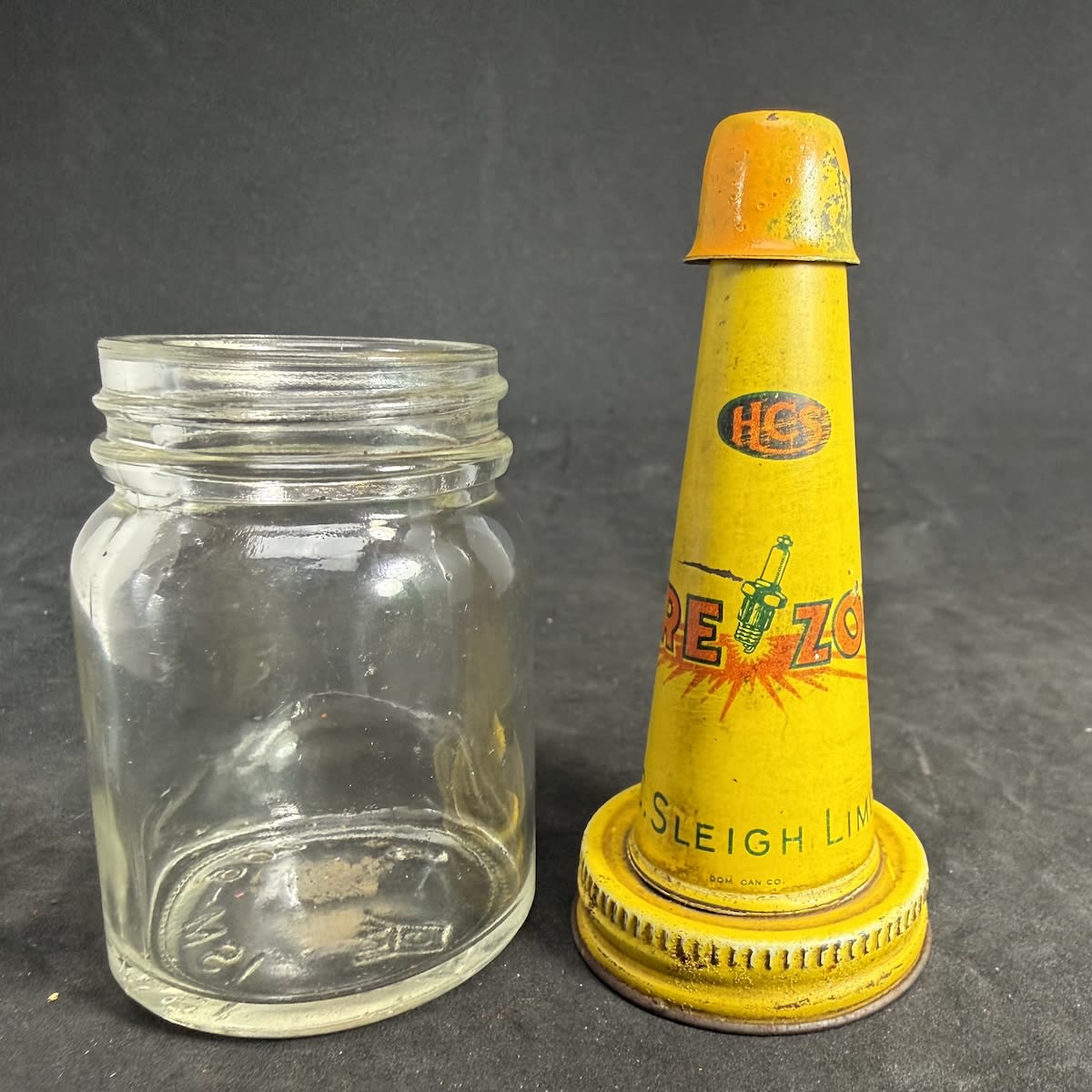 Tin pourer on very small glass jar. HCS Firezone, Sparkplug, H. C. Sleigh Limited. Modern AGM Monogram ISM 902 on jar.