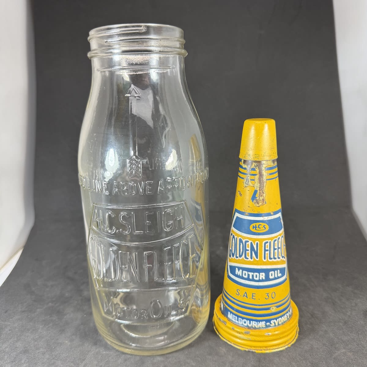 Tin Oil Pourer and Glass Bottle. Golden Fleece Motor Oil. H. C. Sleigh. Embossed bottle H. C. Sleigh Golden Fleece Motor oils in Hex design. Quart.
