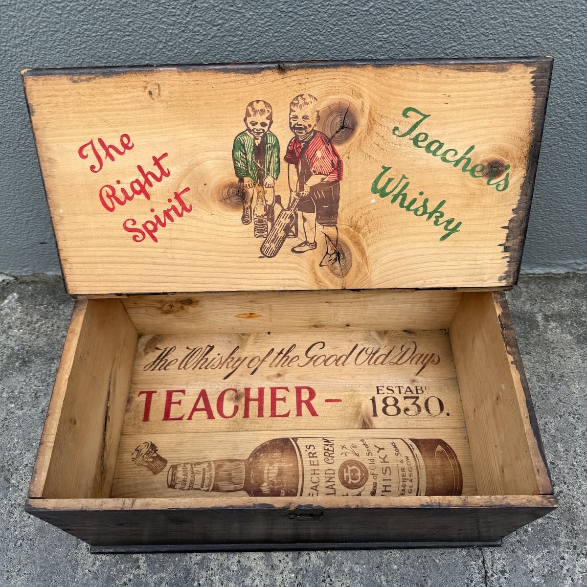 Wooden Box. Printed advertising inside for Teacher's Whisky, The Right Spirit with two boys playing cricket and a whisky bottle with other bottles as the stumps.