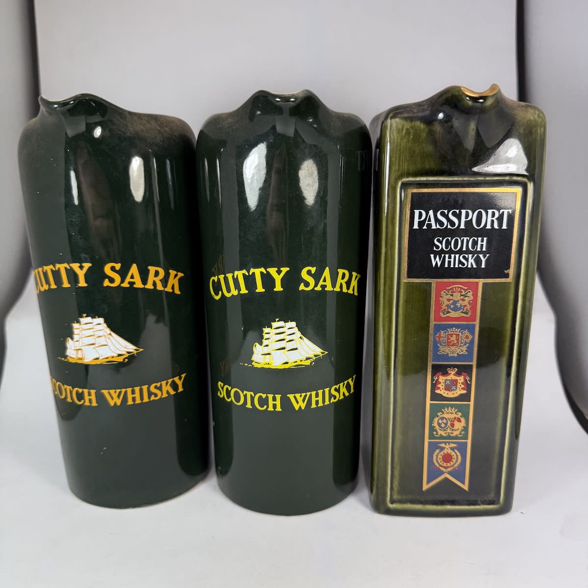3 Whisky Water Jugs: 2 slightly different round Cutty Sark Scotch Whisky; Passport Scotch Whisky.