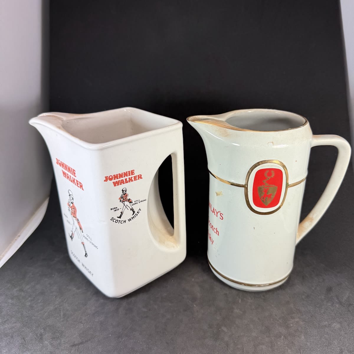 2 Whisky Water Jugs: Japanese made Johnnie Walker Scotch Whisky; Mackinlay's Old Scotch Whisky.
