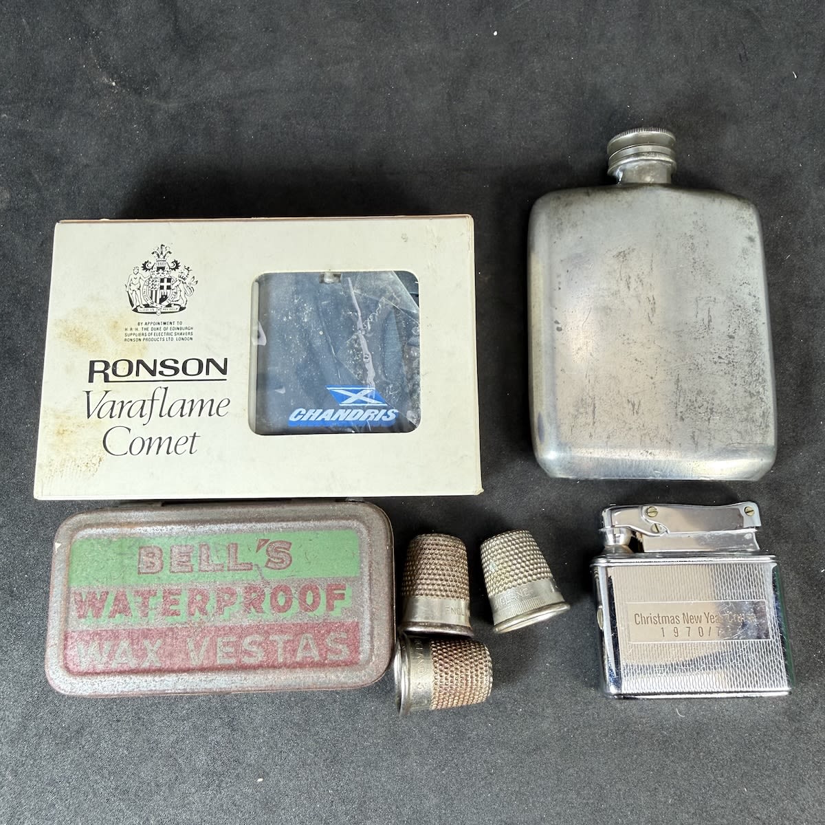 7 Small Items: 1.5 oz Davis Piccadilly Nip Flask; Ronson Varaflame lighter in box; Fairstar Cruise 1970/71 Lighter; Bells Vesta Tin; 3 Metal Thimbles.