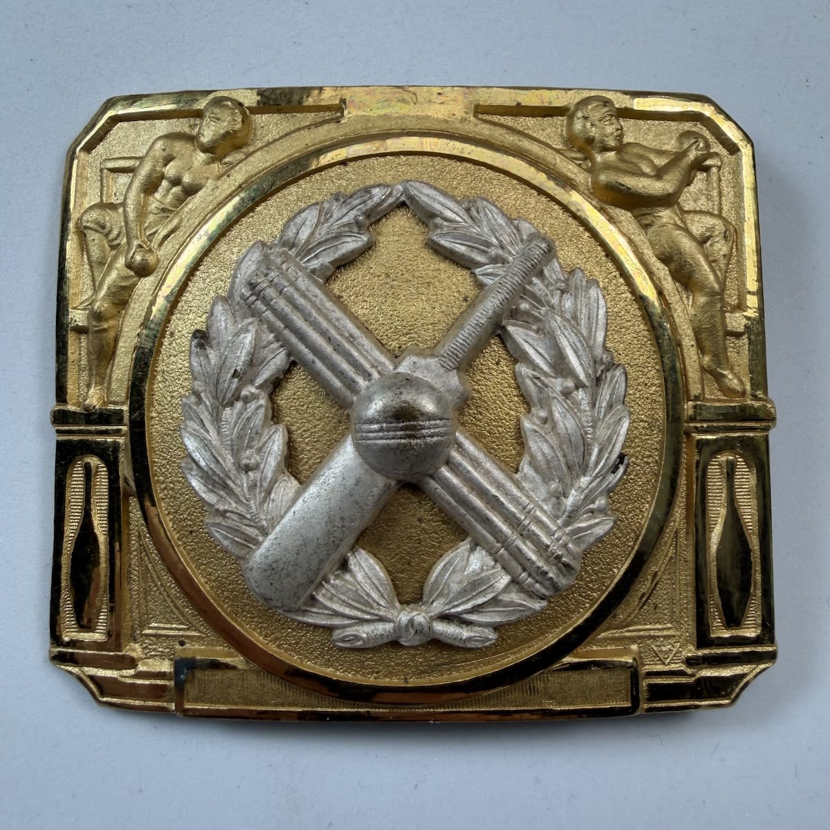 Cricket Belt Buckle / Sash Buckle. Bat crossed with stumps and a ball in the centre, wreath around. Bowling figures to the sides and club shaped bats. New old stock - original gilt and frosted white finish.