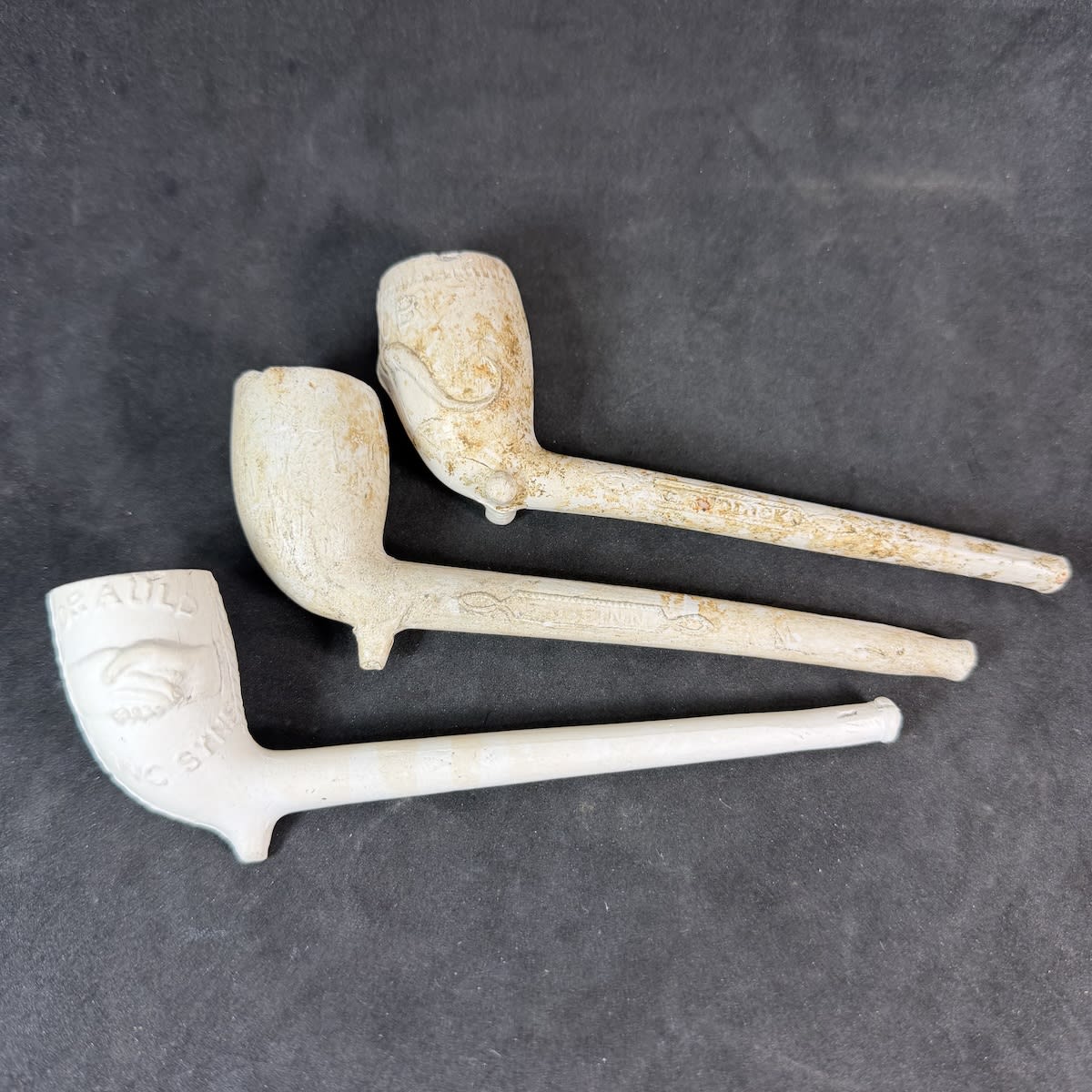 3 Complete Clay Pipes: For Auld Lang Syne, Clasped Hands; Love Heart with cross hatched pattern; RAOB, Royal Ancient Order of Buffaloes.