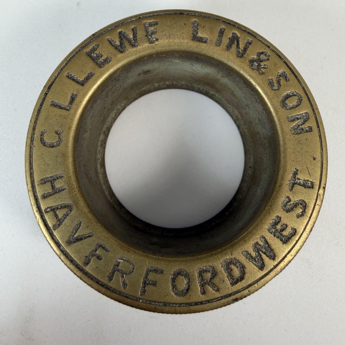 Brass tap surround or similar. G. Llewellin & Son, Haverford West. (Makers of Butter Churns and Dairy implements).