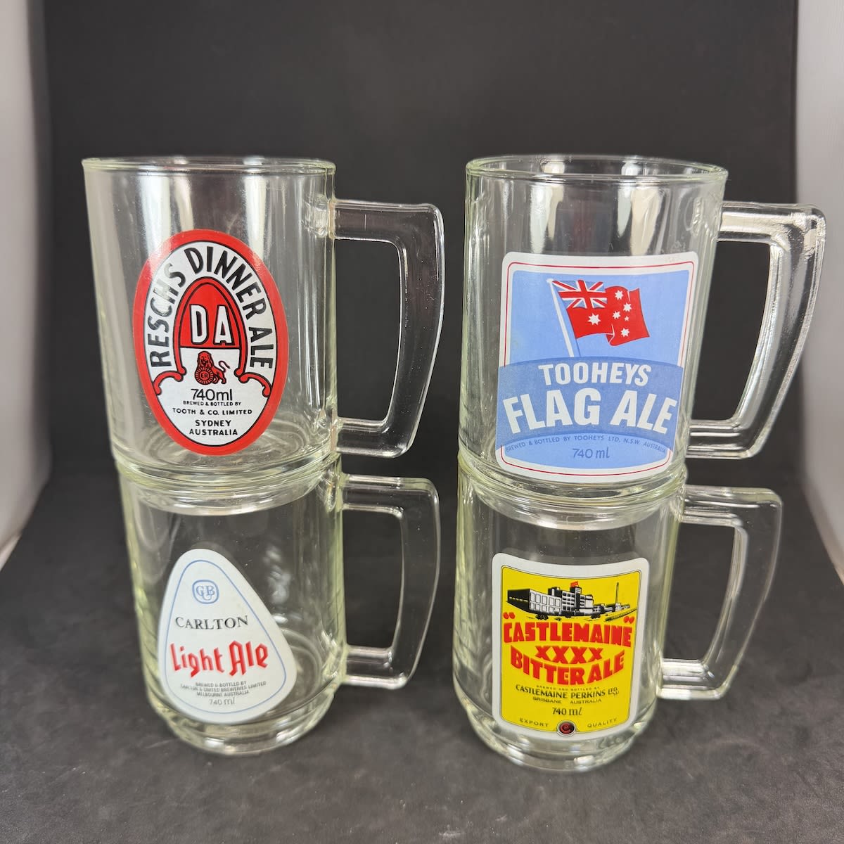 4 Handled Beer Glasses, Beer Mugs. Reproduced prints of old labels: Castlemaine XXXX Bitter Ale; Tooheys Flag Ale; Reschs Dinner Ale; Carlton Light Ale.