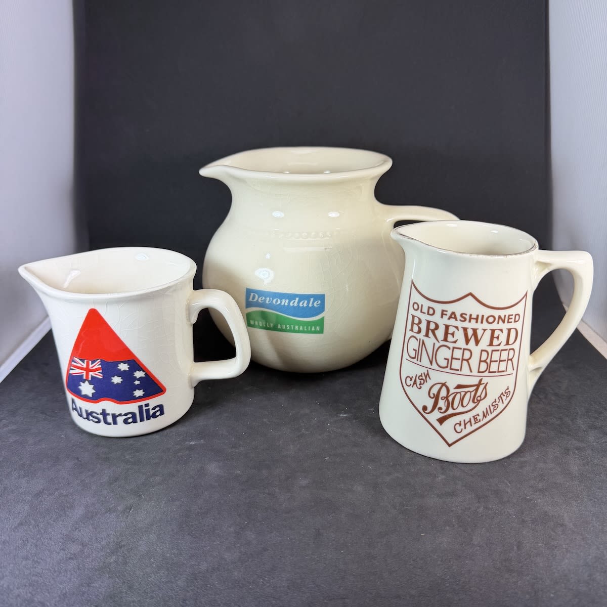 3 Printed Pottery Jugs: Devondale, Wholly Australian, Bendigo Pottery; Boots Cash Chemists Old Fasioned Brewed Ginger Beer; Australia with Made in Australia logo, Johnson.