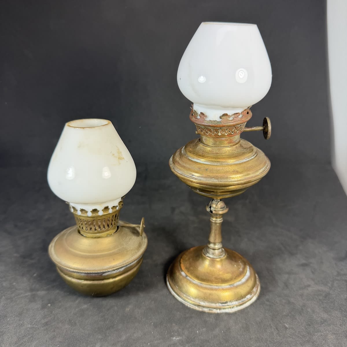 2 small Nightlight type lamps. Brass. Milk glass chimneys. Squat one with heavy base and tall with a tilt mechanism.