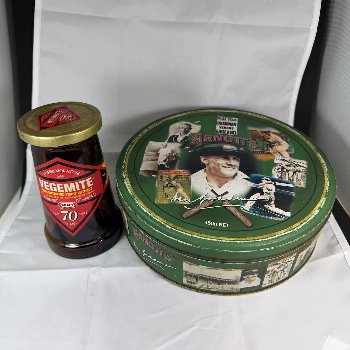 2 Australian Icons! Arnott's tin featuring Sr Donald Bradman; Vegemite 70th Anniversary jar 1922 - 1992.